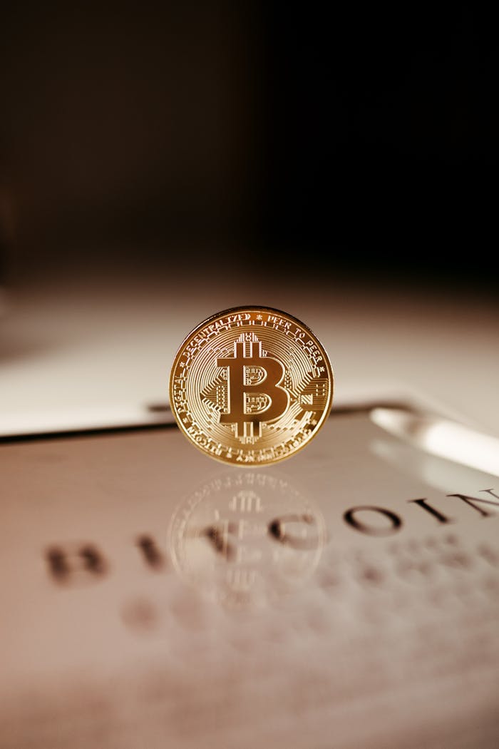 A close-up of a golden Bitcoin coin standing on a tablet, showcasing cryptocurrency technology.