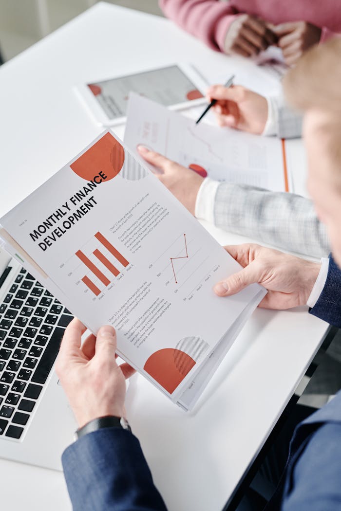 services-02 Professional setting with hands analyzing financial documents during a business meeting.